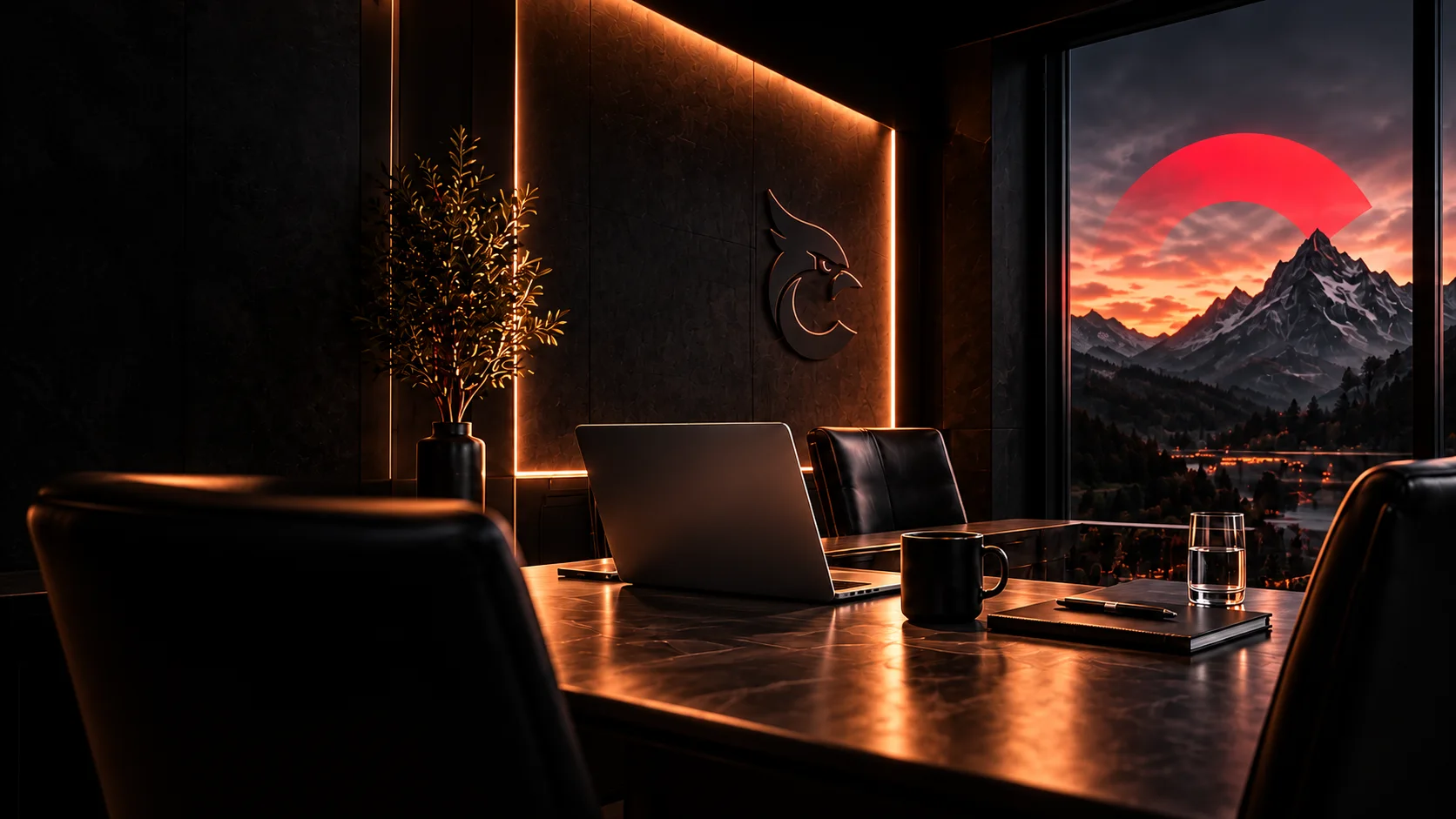 Besprechungsplatz mit Laptop und Tasse im warmen Licht, Cardinahl-Signet an der Wand und Blick auf Berge im Abendrot